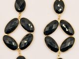 a pair of black stone earrings on a white background