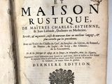 un vieux livre est ouvert sur une surface blanche, avec une étiquette accrochée dessus