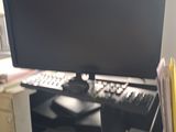 a computer monitor sitting on a desk next to a keyboard