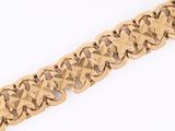 a close up of a gold bracelet on a white surface