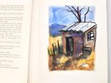an open book with a picture of a house on it