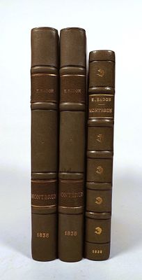 four books are lined up in a row on a white surface