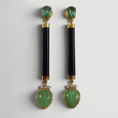 une paire de boucles d'oreilles noires et vertes ornées d'une pierre verte