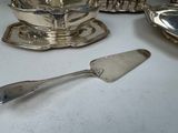 a silver plate with a silver spoon and a silver plate with a silver spoon and a silver plate with a silver spoon and a silver plate with a silver