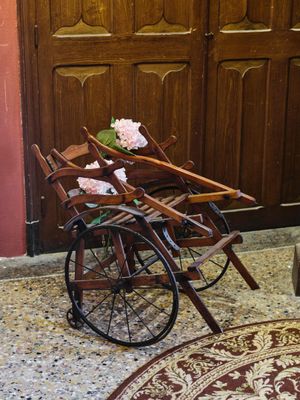une charrette en bois sur laquelle sont empilées plusieurs chaises en bois