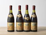 quatre bouteilles de vin sont alignées sur une table en bois