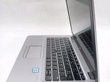 a silver laptop computer sitting on top of a white table