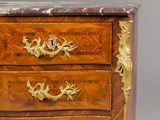 a small chest of drawers with a marble top