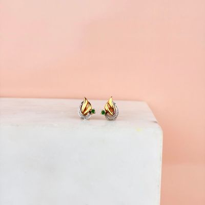 des boucles d'oreilles à clous plaquées or posées sur un bloc de marbre, sur fond rose
