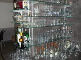 de nombreux verres et bouteilles posés sur le comptoir dans la pièce