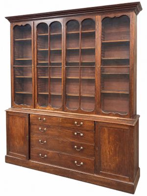 une photo représentant une grande bibliothèque en bois avec des tiroirs et des étagères