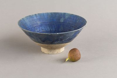 un petit bol bleu contenant un fruit