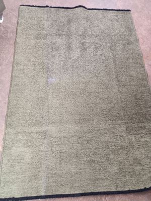 Le tapis se trouve par terre, à côté d'une chaise dans la pièce.