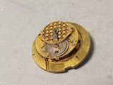 a small gold button with a clock inside of it