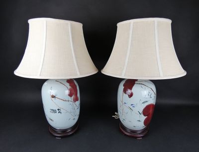pair of red and white vase lamps with lampshads on black background
