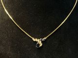 a gold necklace with a black and white stone pendant on a mannequin