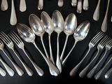 a lot of silver spoons and forks on the table