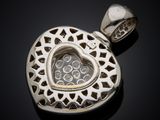 a close up of a heart shaped pendant on a black surface