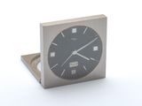 une horloge en métal avec un cadran noir sur un fond blanc