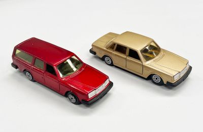 deux voitures jouets assises l'une à côté de l'autre sur une surface blanche