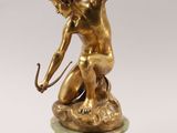 bronze figurine of a boy shooting a bow on a marble base