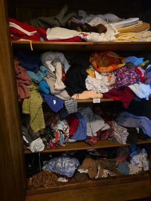 a closet full of clothes and shoes in a closet