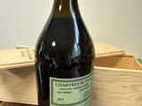 une bouteille de vin posée sur une table à côté d'une caisse en bois