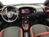 the interior of a small car with red trims and a steering wheel