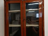 a wooden cabinet with two glass doors on it