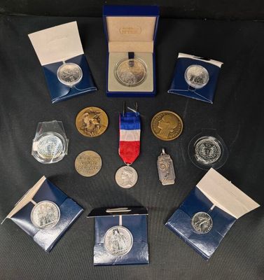 un ensemble de pièces d'argent et d'or ainsi qu'une médaille posés sur une table