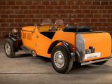 an orange and black car parked in front of a brick wall