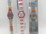 trois montres dans leur emballage en plastique, posées sur une surface blanche