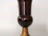 un vase marron avec un socle doré sur fond blanc