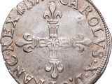 an old silver coin with a cross on it