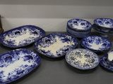 de nombreuses assiettes et bols bleus et blancs sur la table
