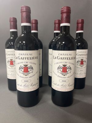 quatre bouteilles de vin rouge sont alignées sur une table