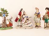 five figurines of people in different styles and colors