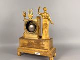 a gold clock with a statue on top of it