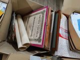 a cardboard box full of books and papers on the floor