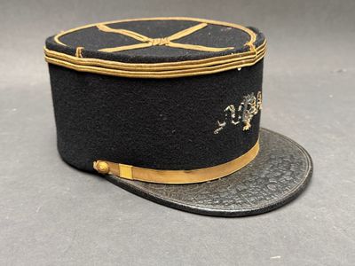 chapeau noir orné d’une bordure dorée et d’un ruban sur le dessus