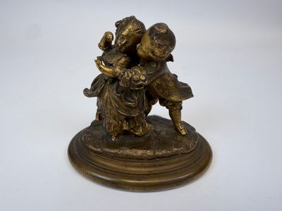 figurine antique en bronze représentant un garçon et une fille tenant un panier