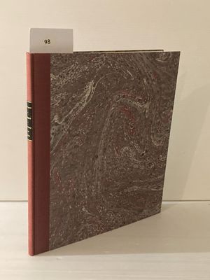un livre à la couverture rouge posé sur une table blanche