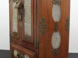 un petit meuble en bois surmonté d'une horloge
