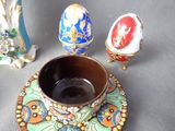 a cup and saucer sitting on a saucer next to two eggs
