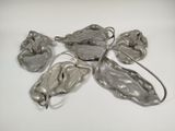 five pieces of silver colored metal on a white surface