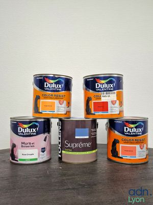 four cans of duluxx paint sitting on a table