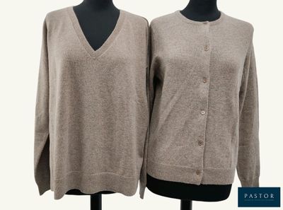 two women ' s sweaters on a mannequin stand