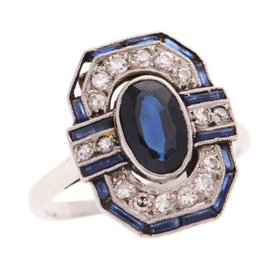 gros plan d'une bague avec une pierre bleue entourée de diamants