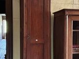 une grande horloge de parquet en bois, à côté d'un grand meuble en bois