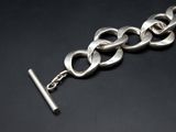 a close up of a silver chain with a bar on it